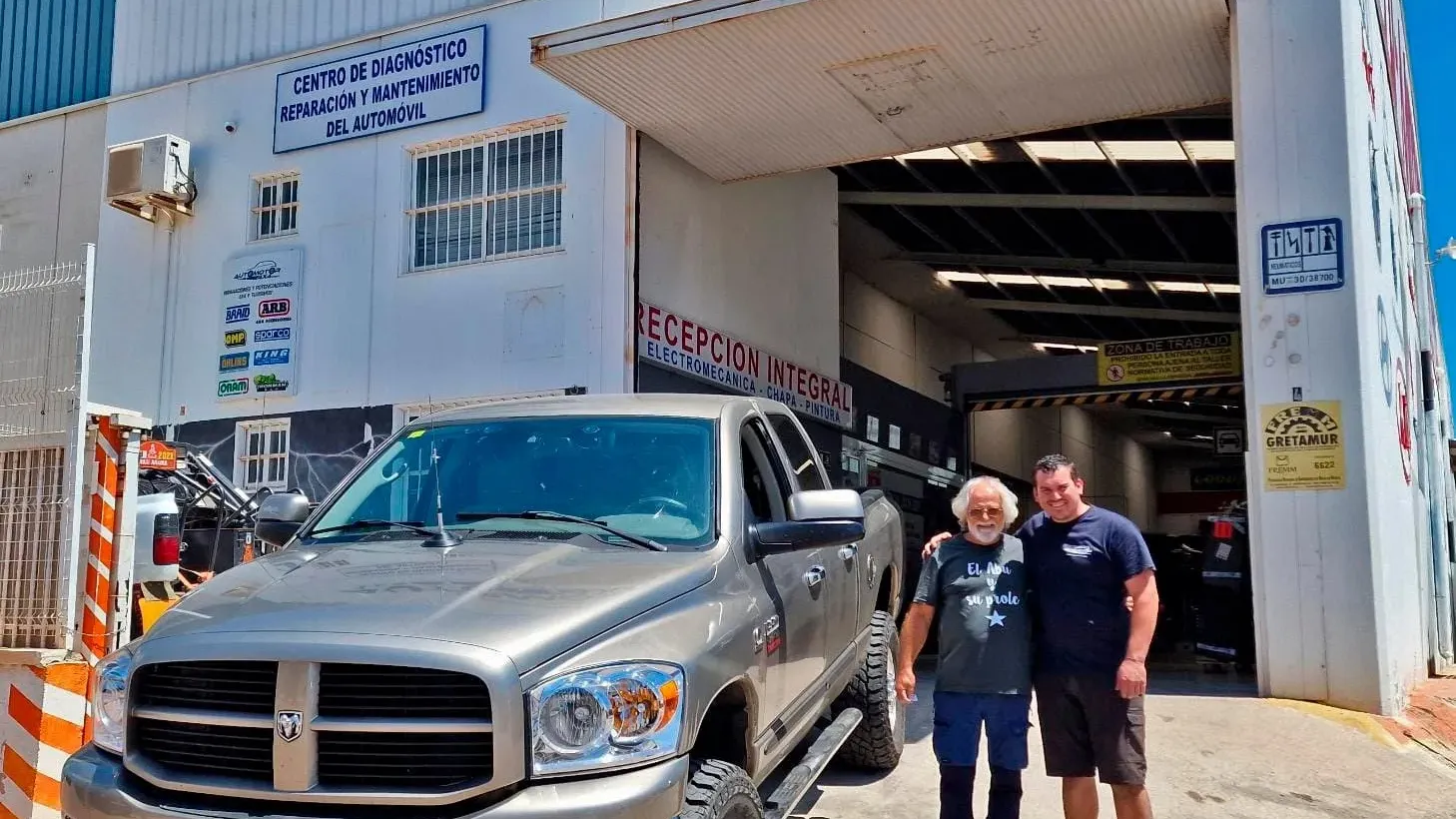 Outside the Automotor 4x4 workshop, roller door open and a prepared Dodge Ram at the entrance
