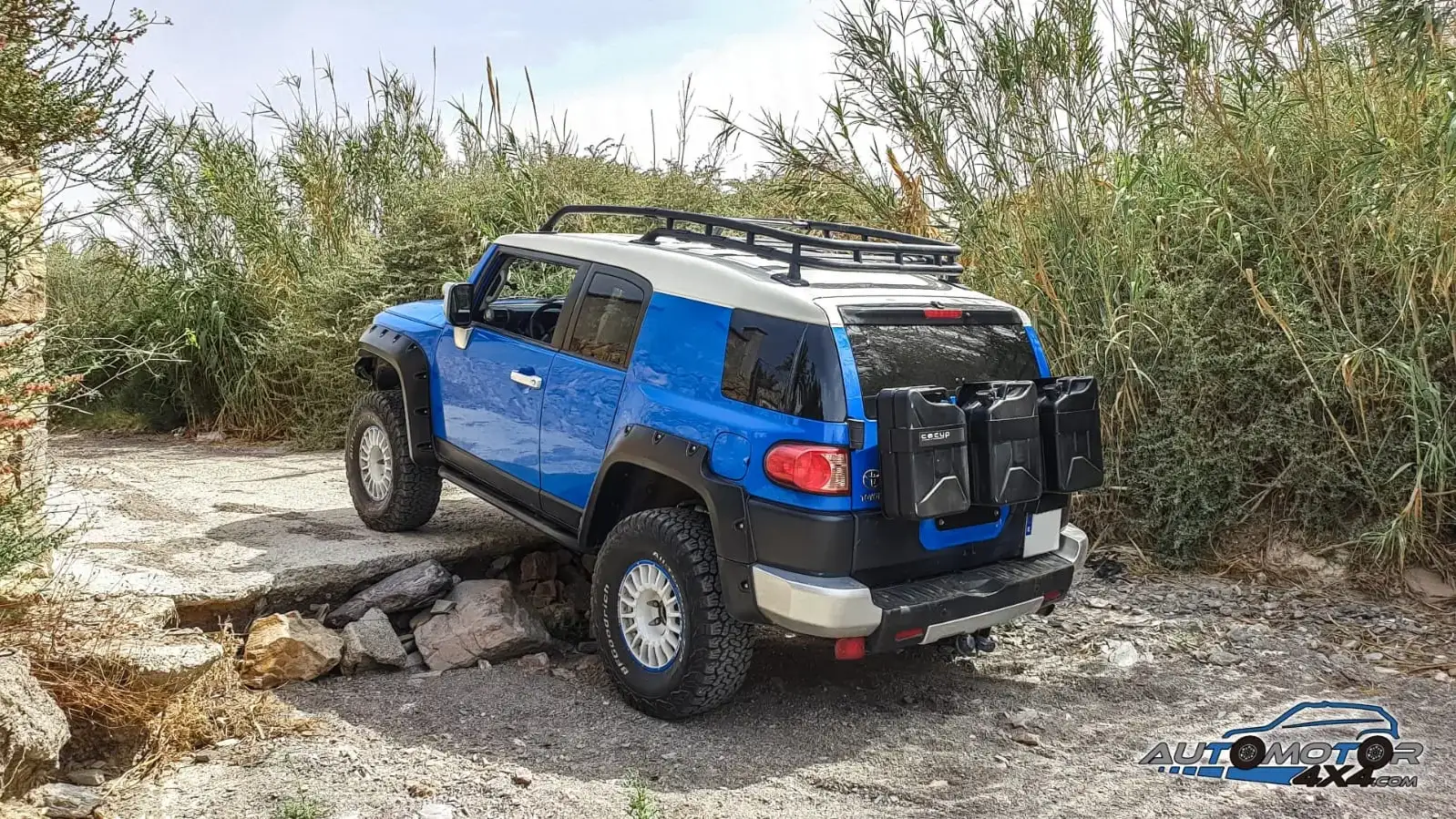 Toyota FJ Cruiser con baca de expedición y bidones, parado en una rambla